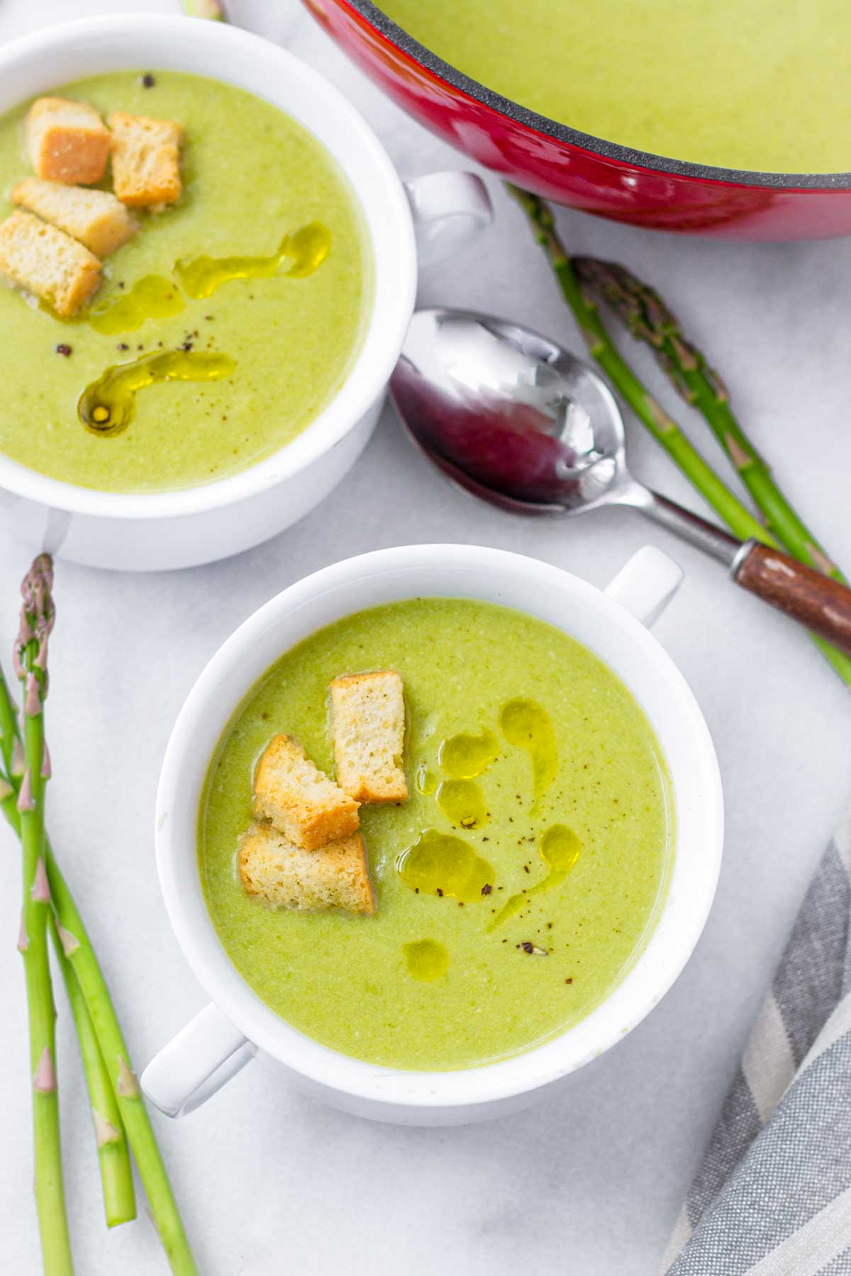 two bowls of asparagus soup made with milk