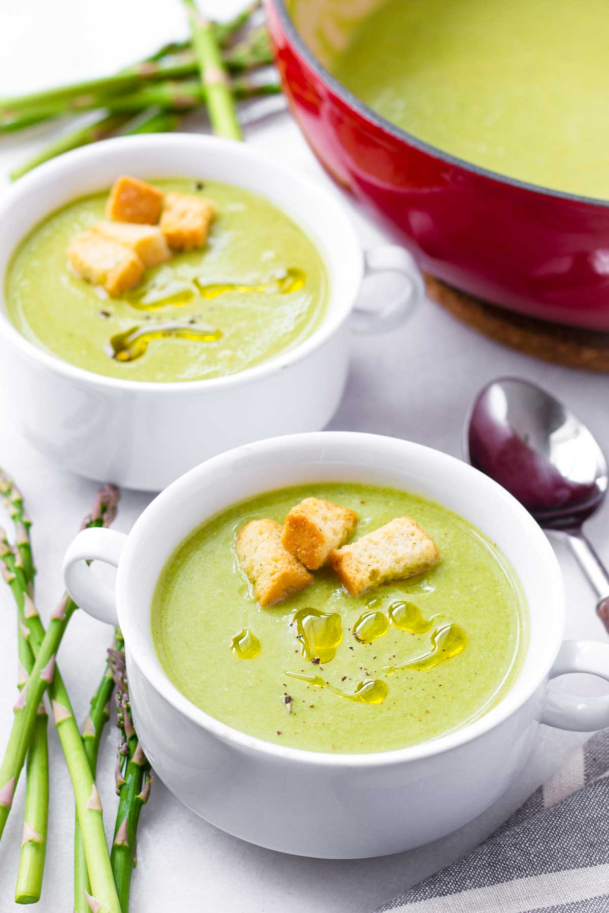 two bowls of creamy asparagus soup made with milk