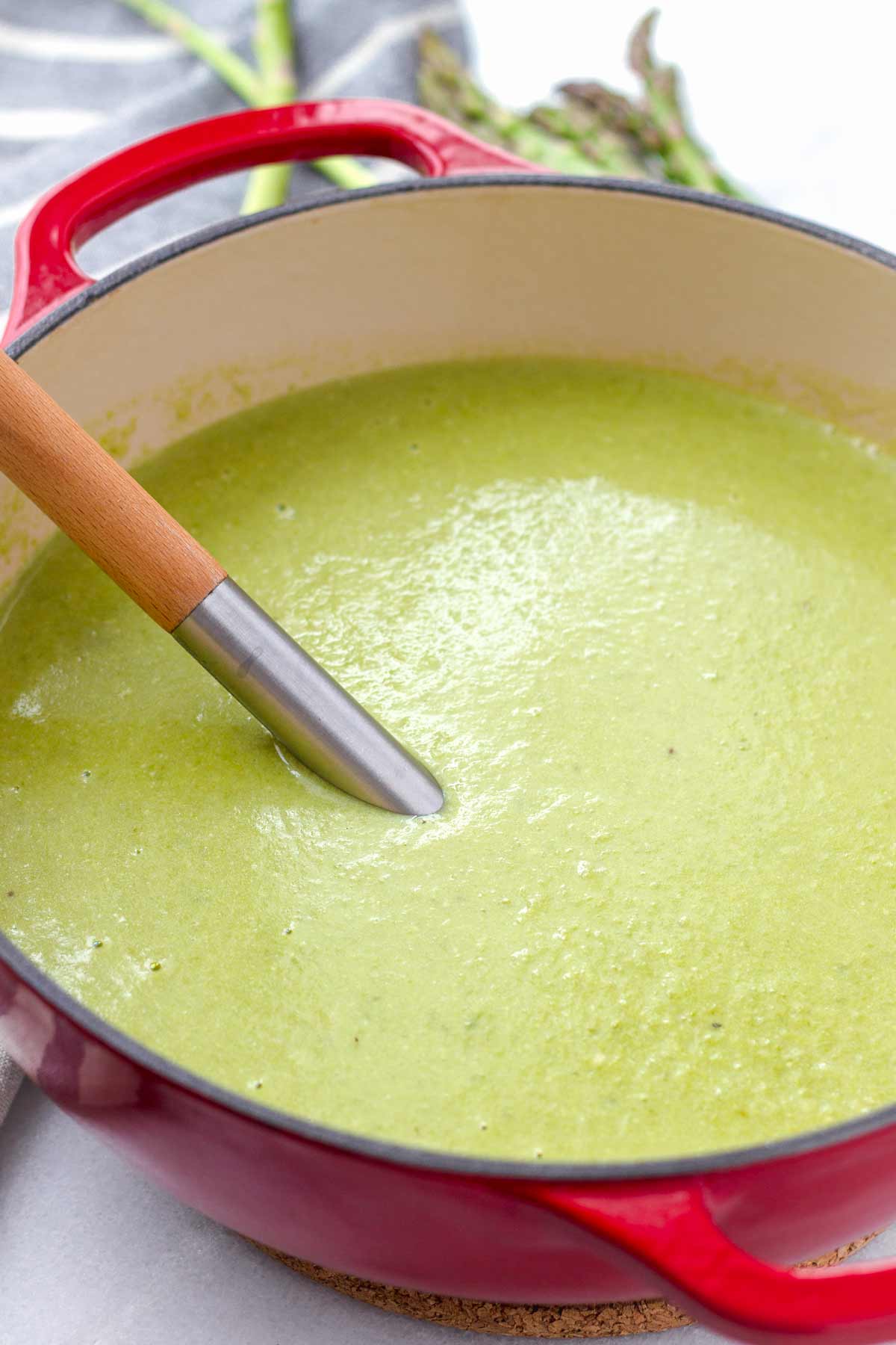 blended asparagus soup in a red dutch oven pot