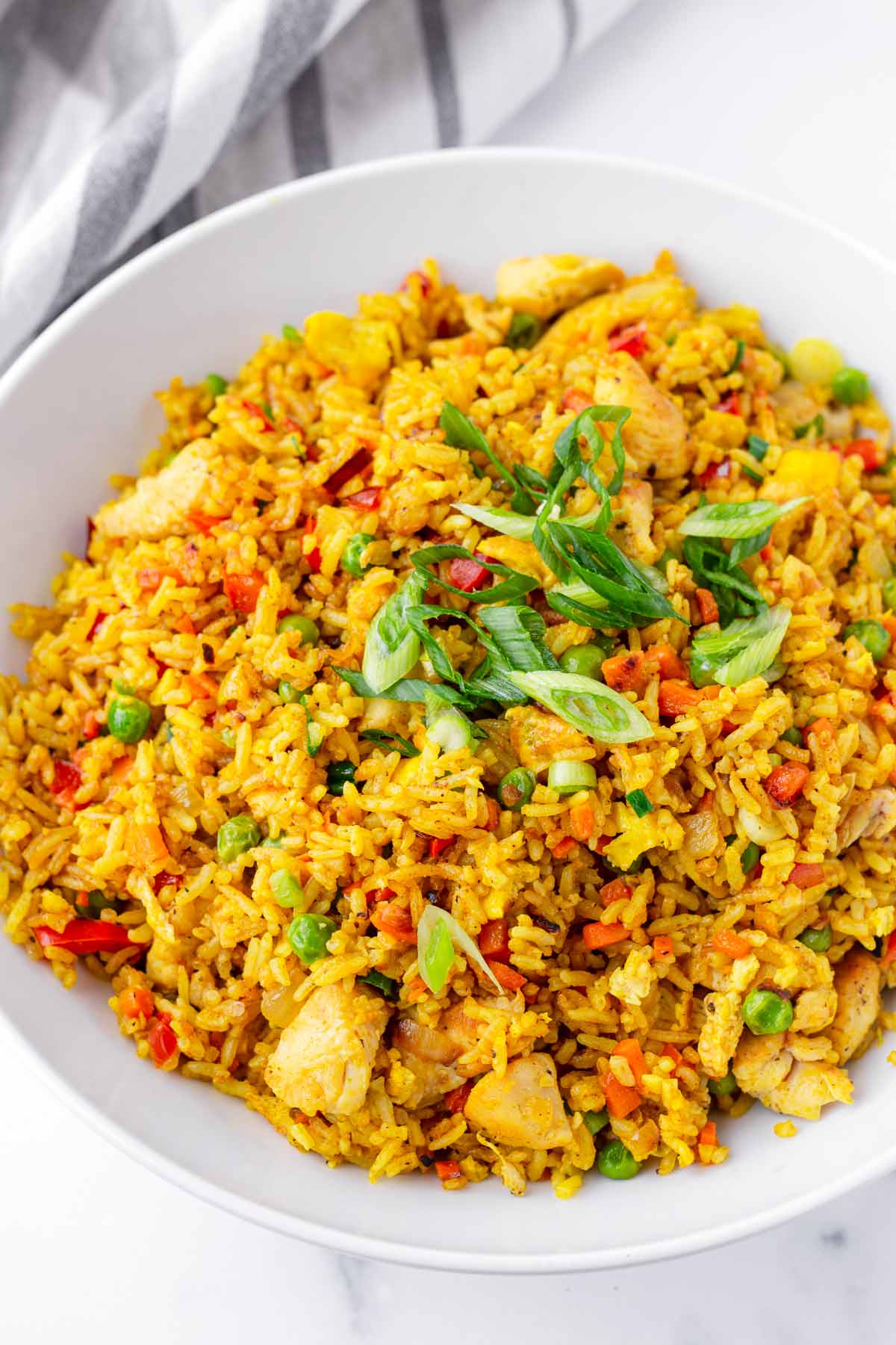 bowl with chicken curry fried rice and green onions garnish