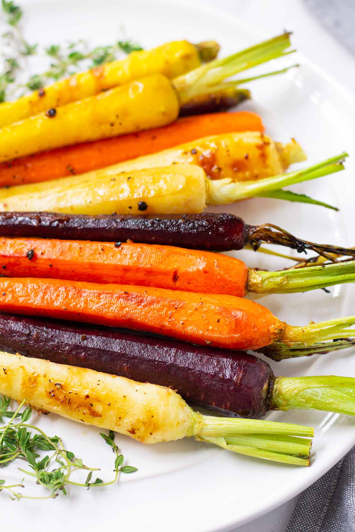 side view of roasted rainbow carrots with seasoning and glaze