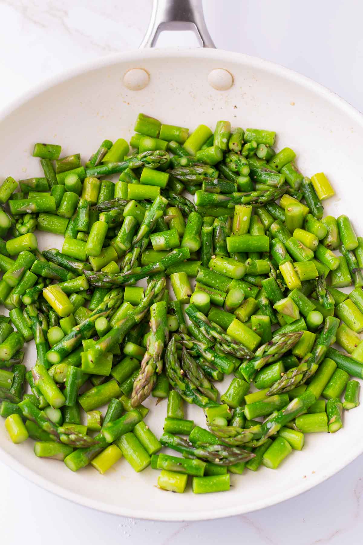 sauteed diced asparagus in a skillet