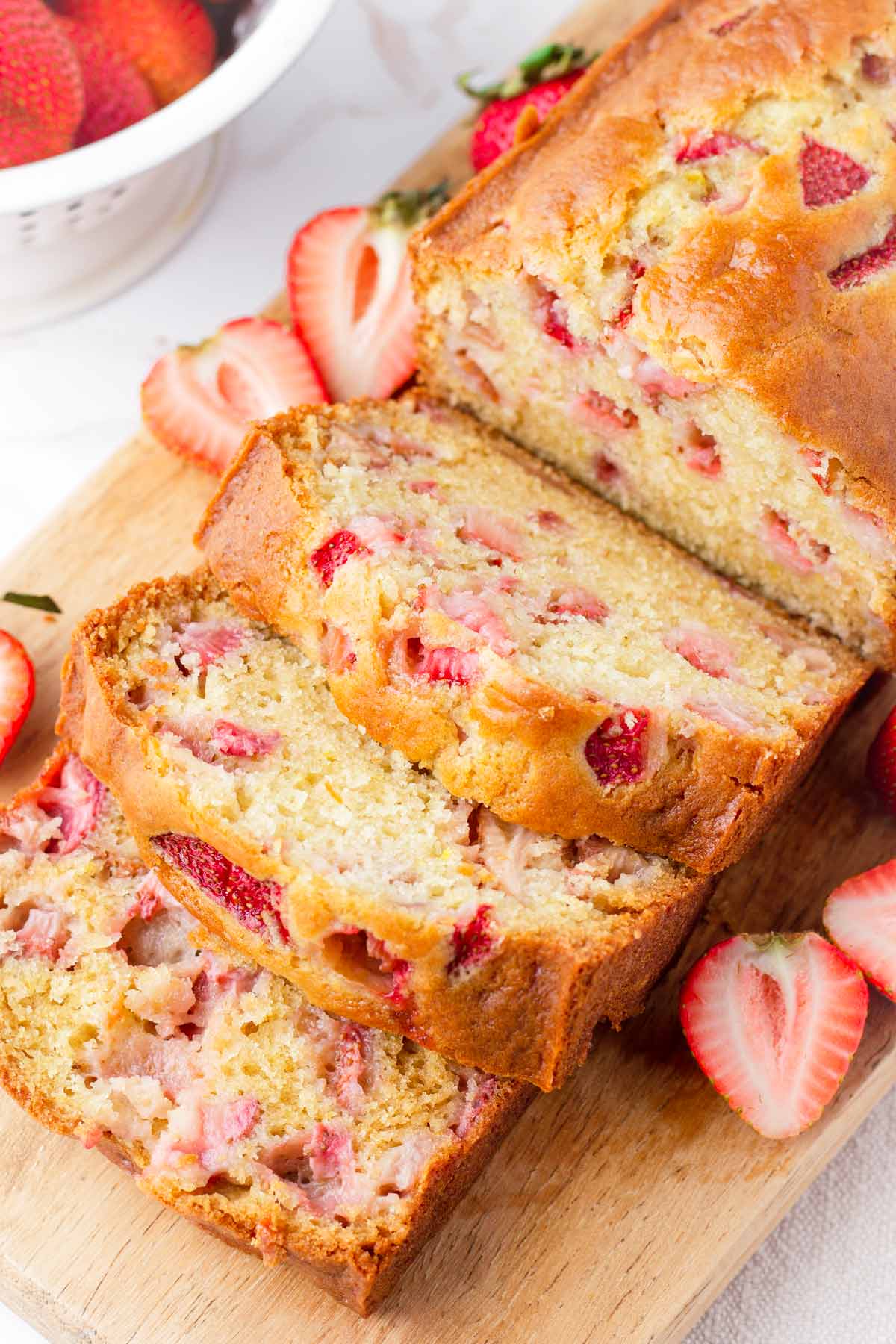 slices of tender quick bread with fresh strawberries inside