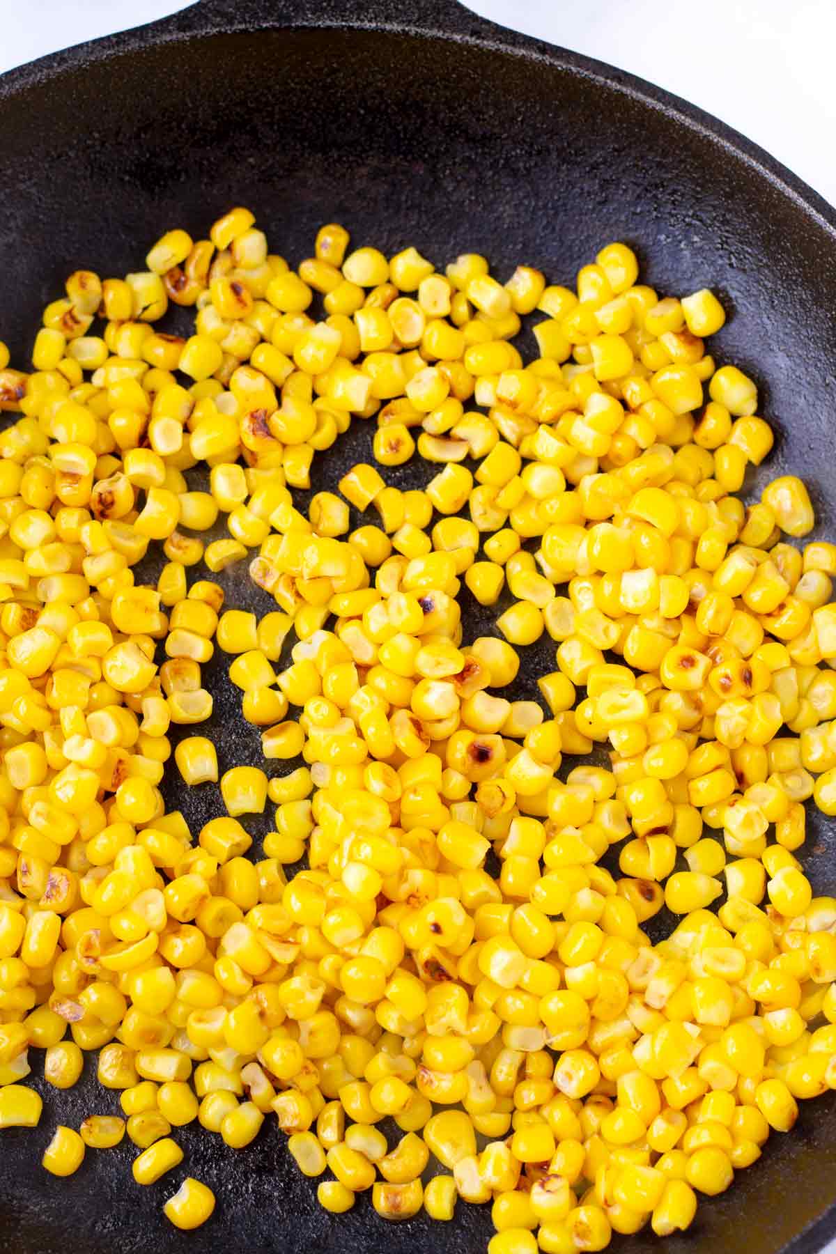 charred corn kernels in a cast iron skillet