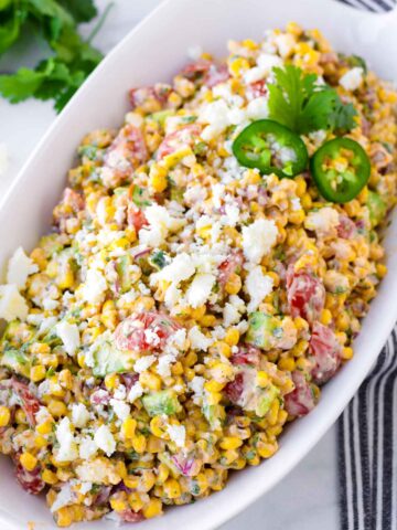 a boat shaped bowl with prepared mexican corn salad