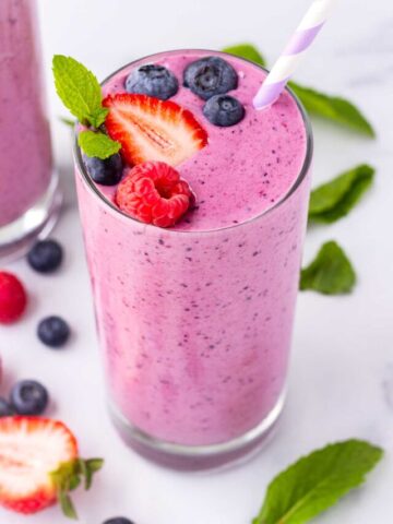 one glass of prepared mixed berry smoothie with purple straw