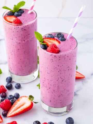two decorated and garnished servings of fresh berry fruit smoothies