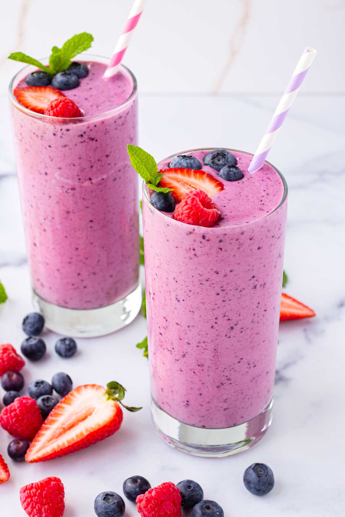 two decorated and garnished servings of fresh berry fruit smoothies