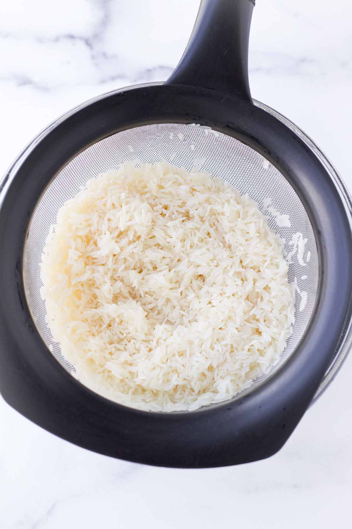 rinsing rice over a colander