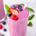 purple mixed berry smoothie with fresh berry and mint topping