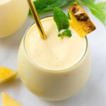 pineapple banana smoothie in glass with garnish