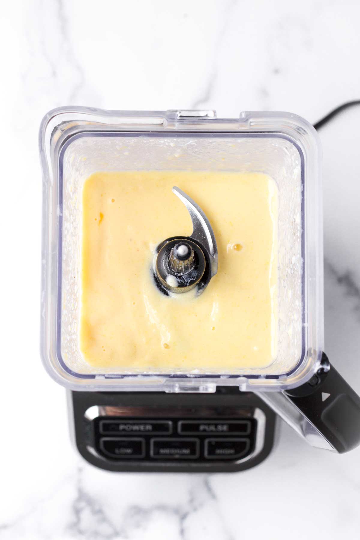 top view of a blended pineapple smoothie inside the blender