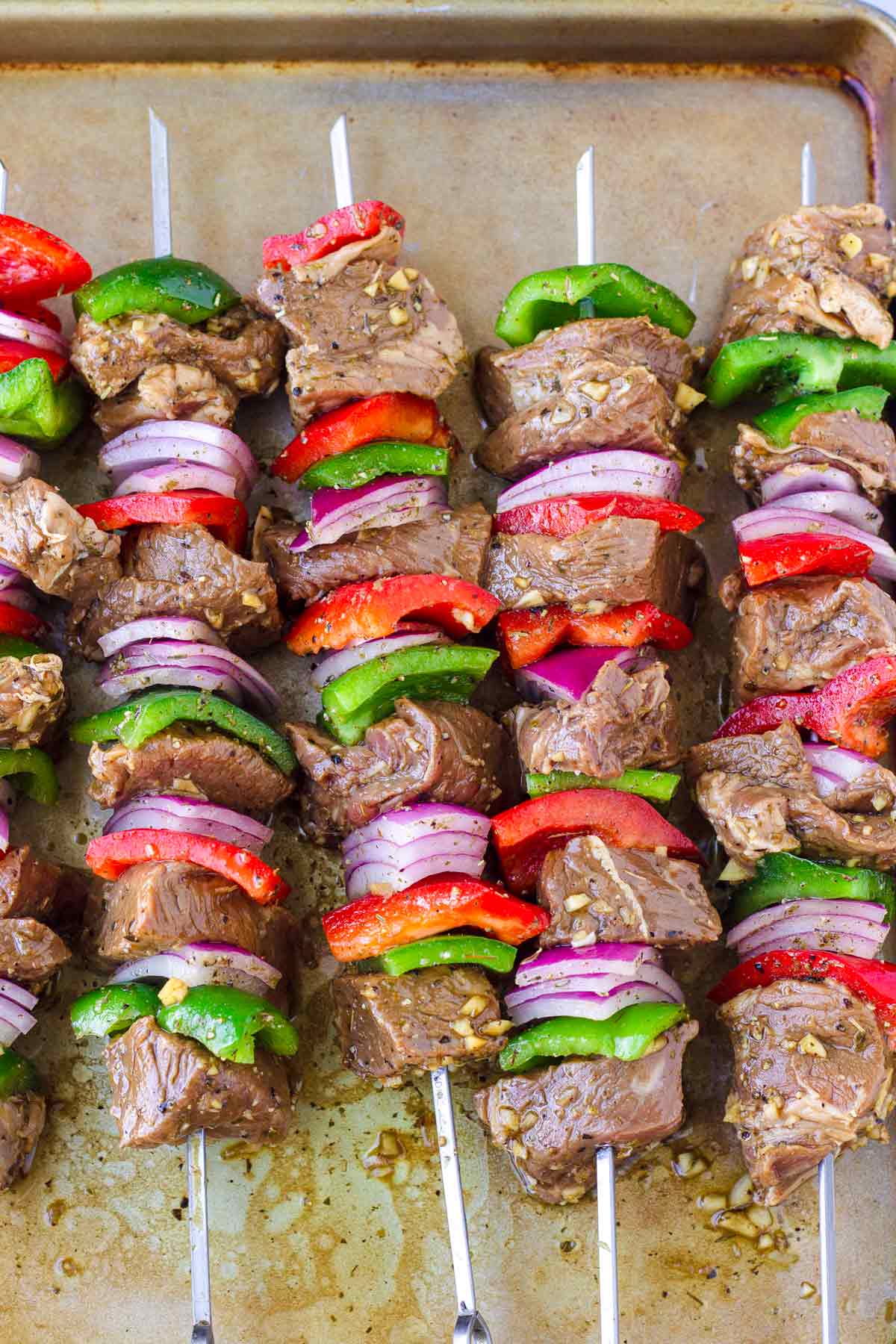 assembled uncooked kabobs on a sheet pan