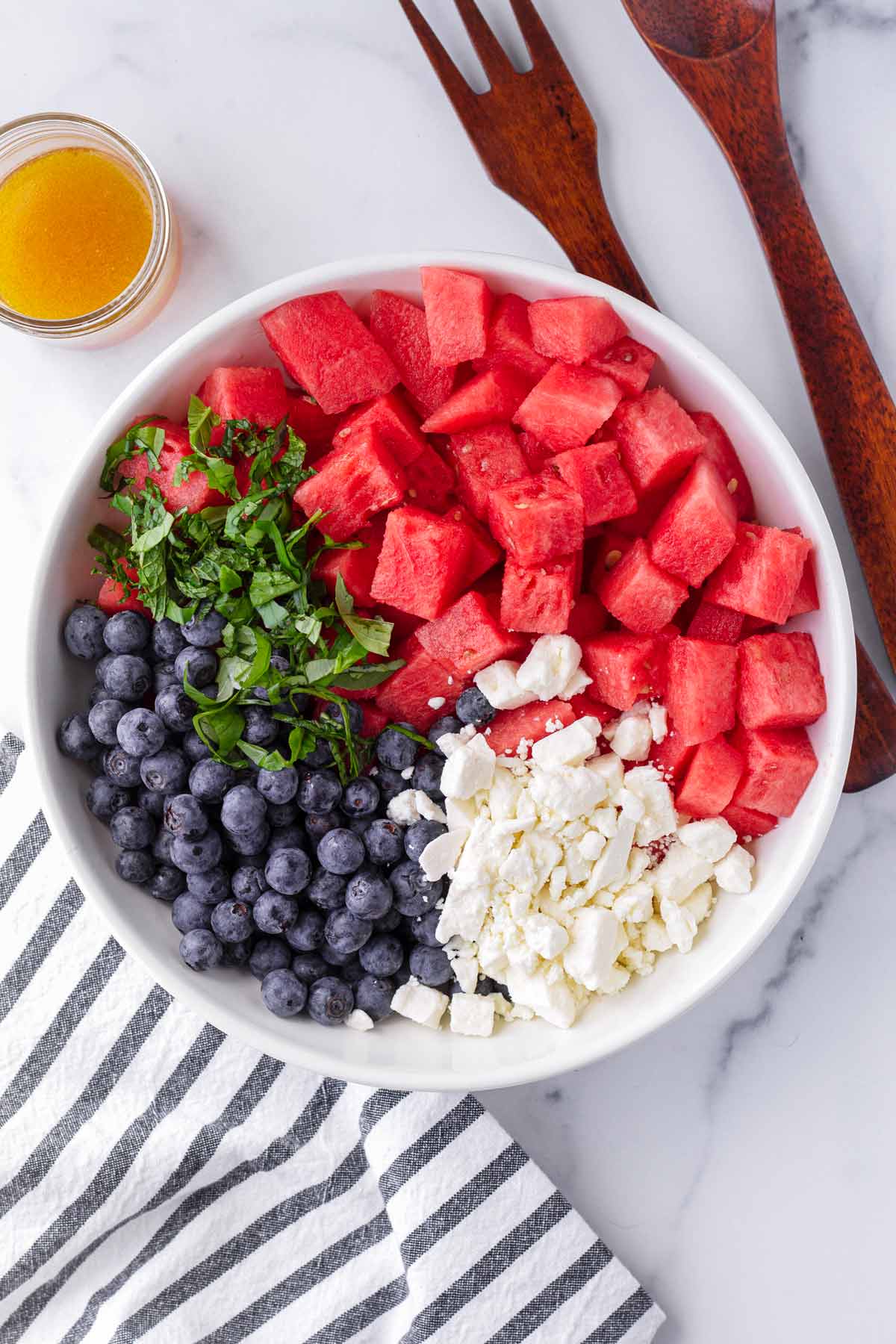 bowl with divided watermelon blueberry feta salad ingredients