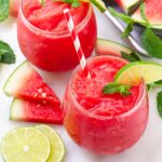 two glasses of frozen watermelon slushie with lime and mint