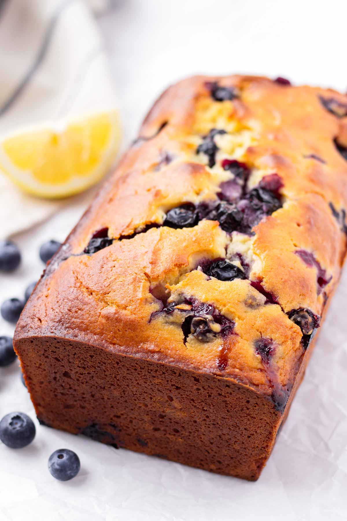 a freshly baked loaf of quick bread bursting with blueberries