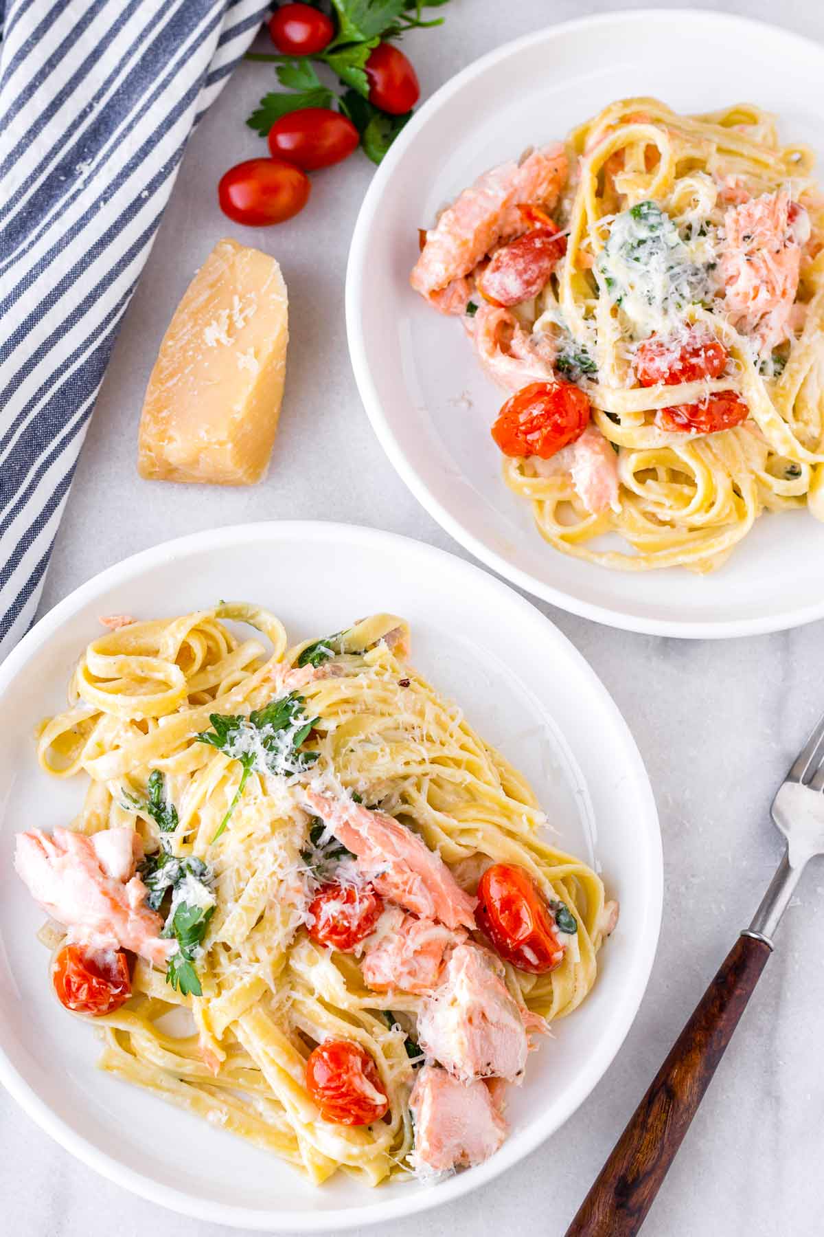 two plates of salmon pasta with creamy sauce
