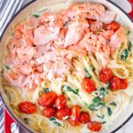 a pot with salmon, roasted tomatoes, spinach, and pasta