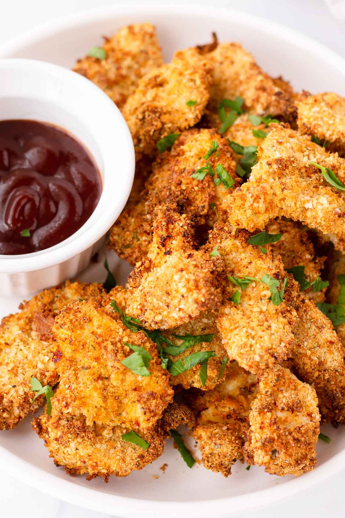 golden brown air fryer chicken nuggets with side of BBQ sauce