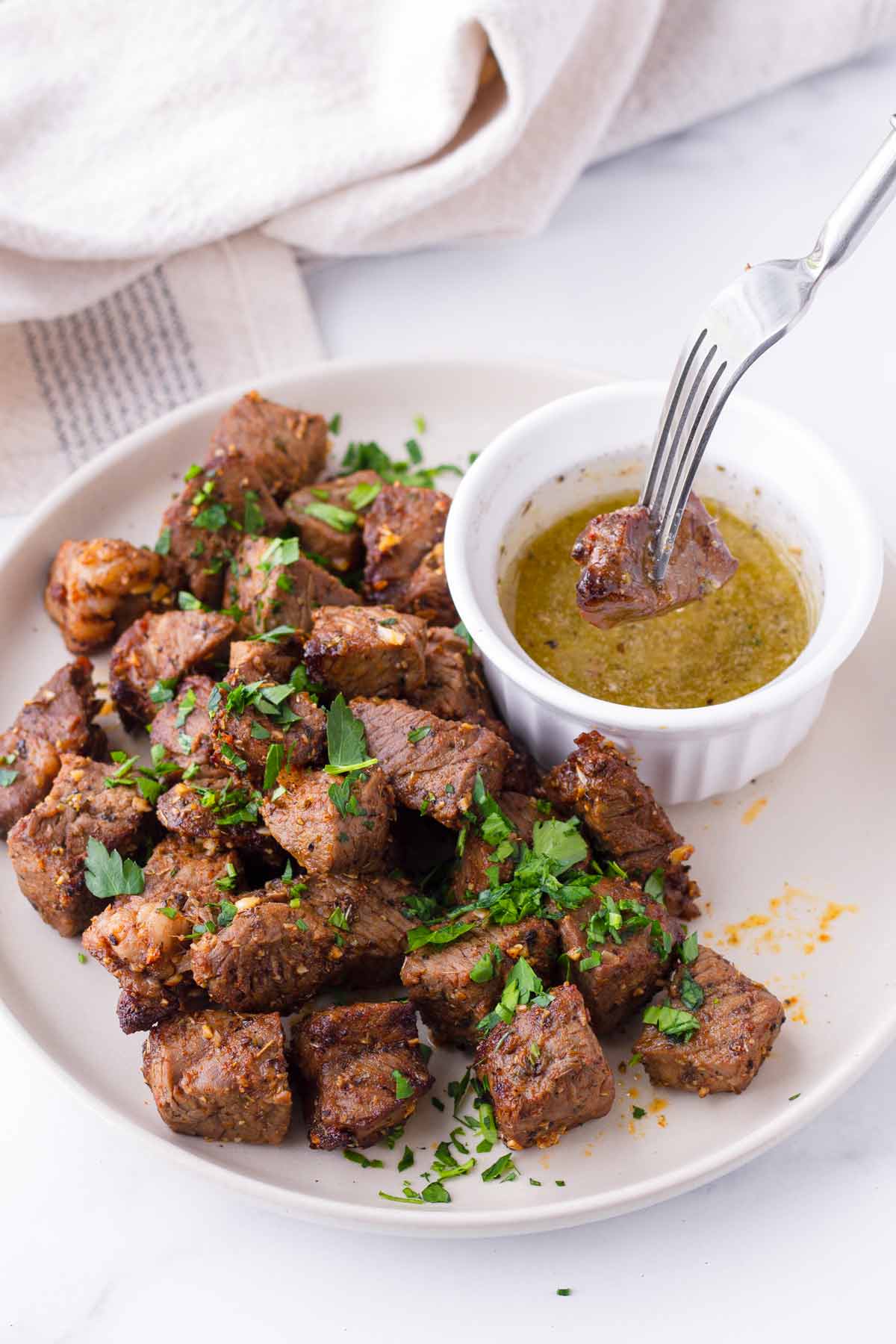 dipping steak bites into melted garlic butter