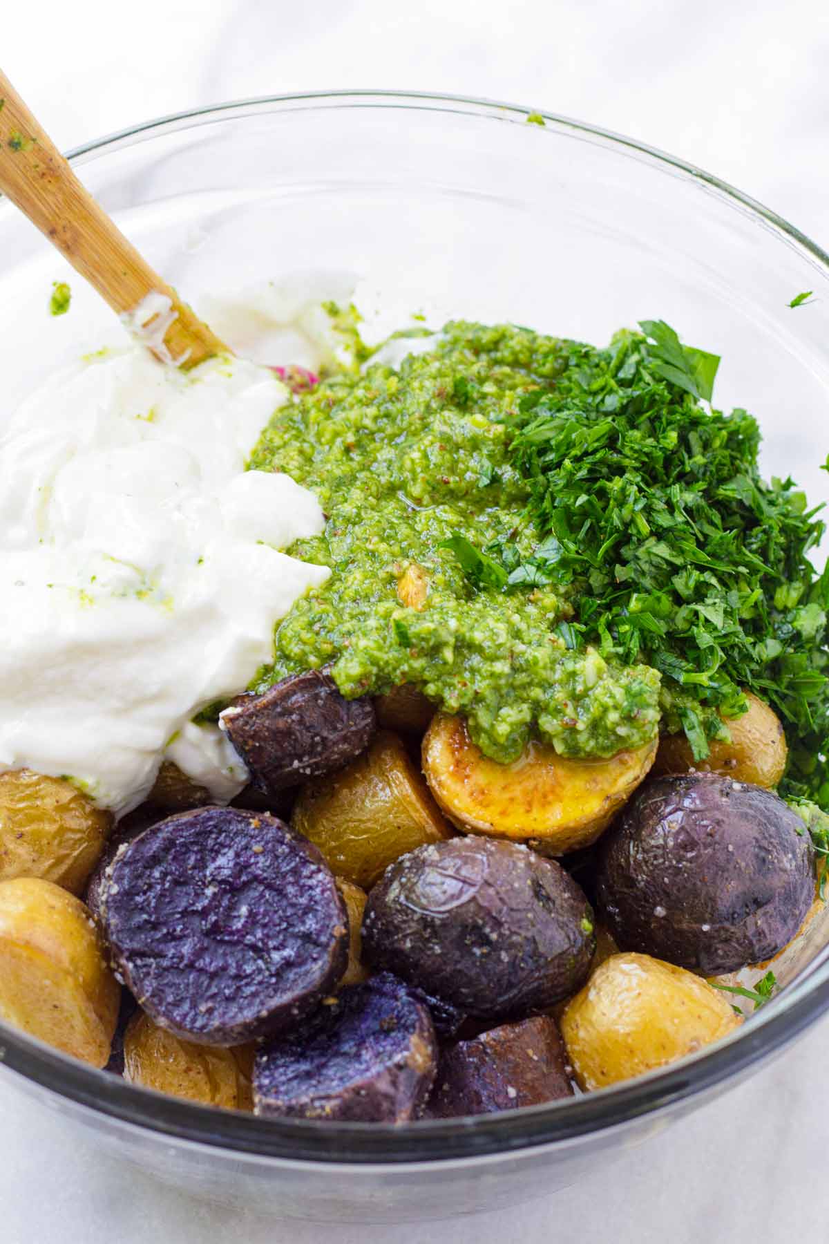 roasted potatoes, parsley, pesto, and yogurt in a bowl