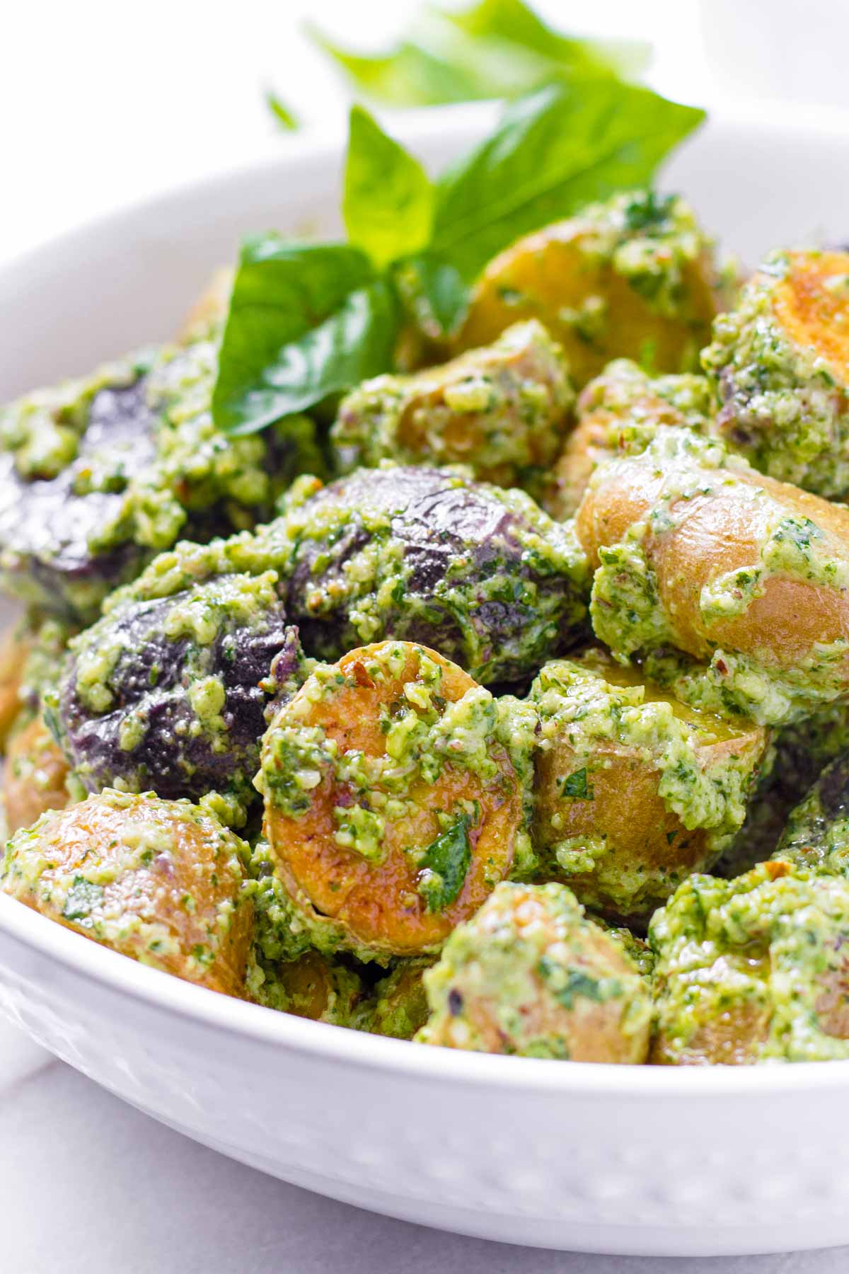 roasted baby potatoes tossed with a creamy basil pesto in bowl