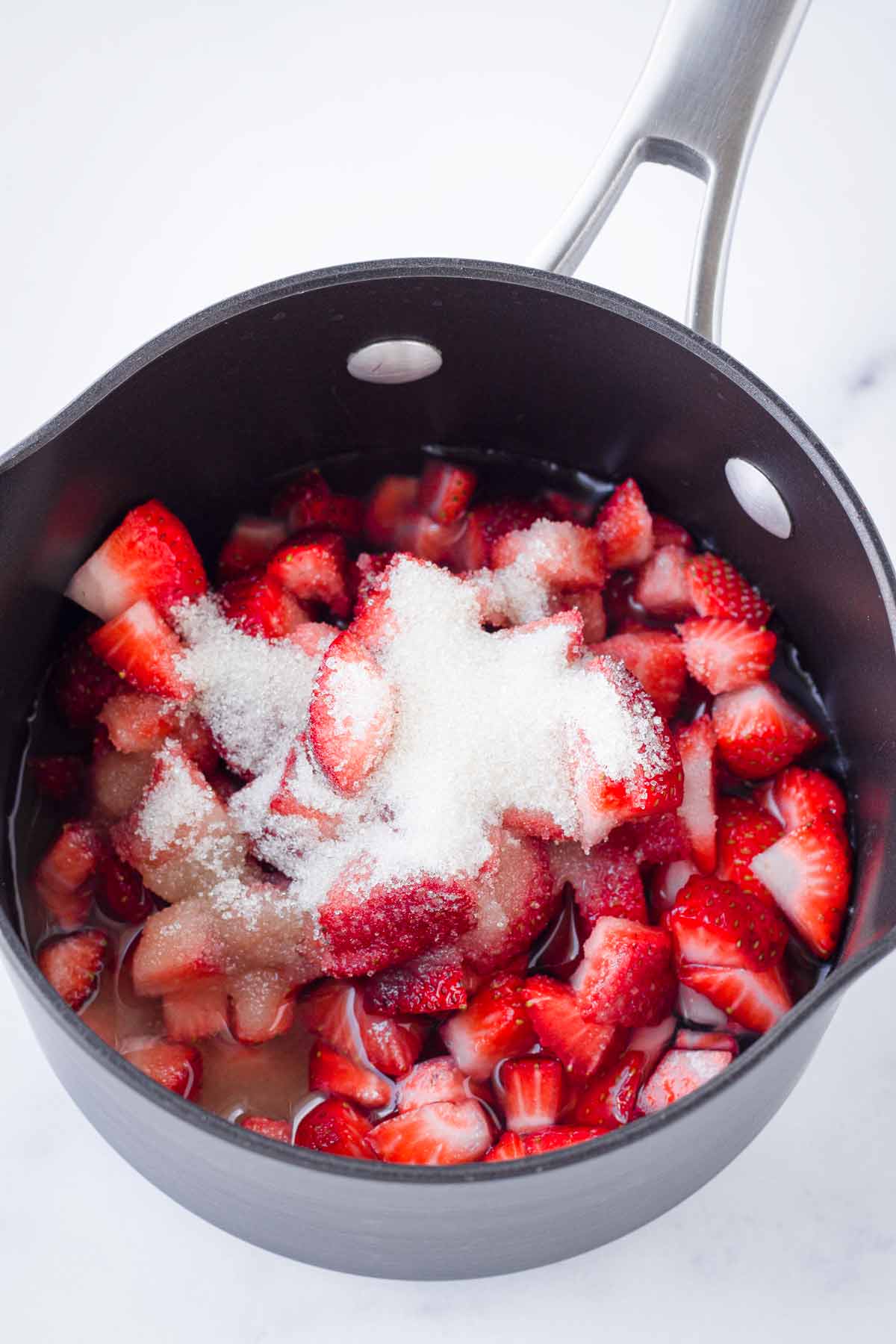 diced strawberries and sugar in a pot