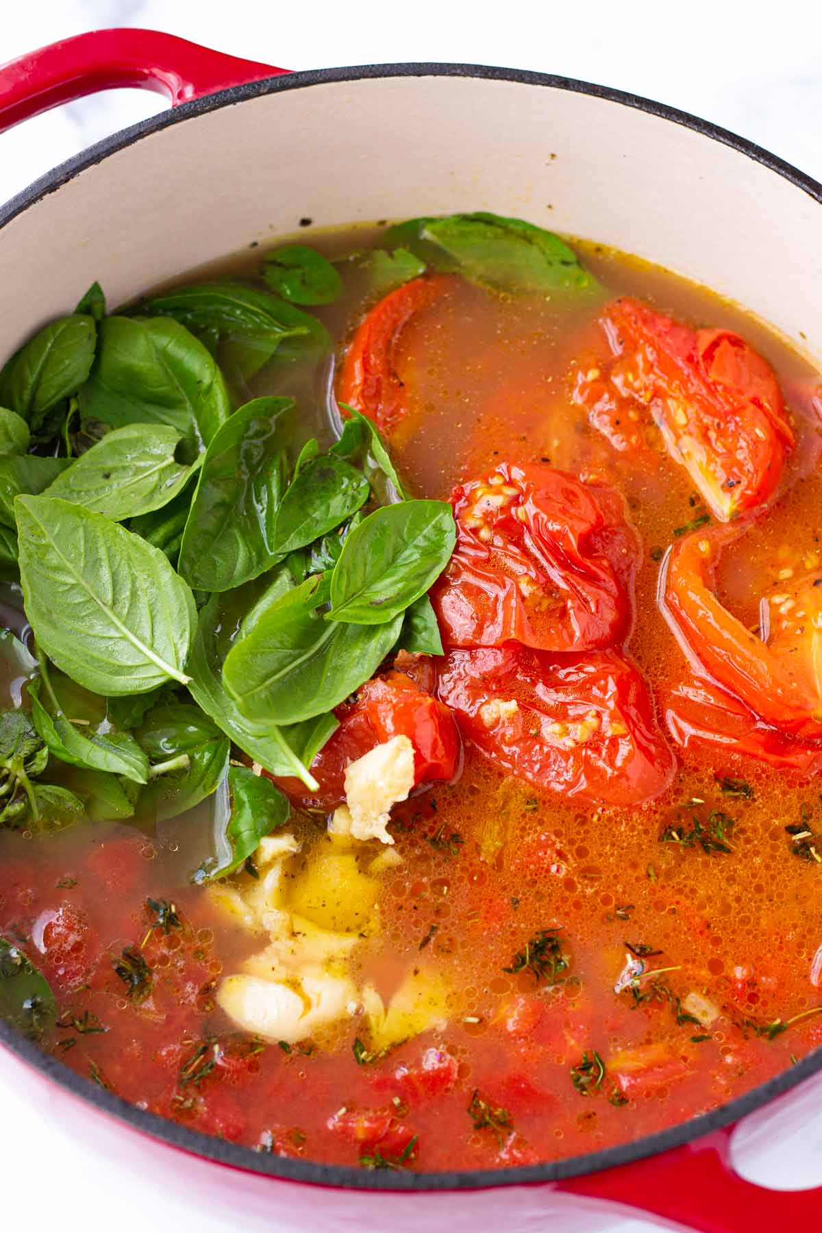 fresh basil, roasted tomatoes, roasted garlic and broth in a pot