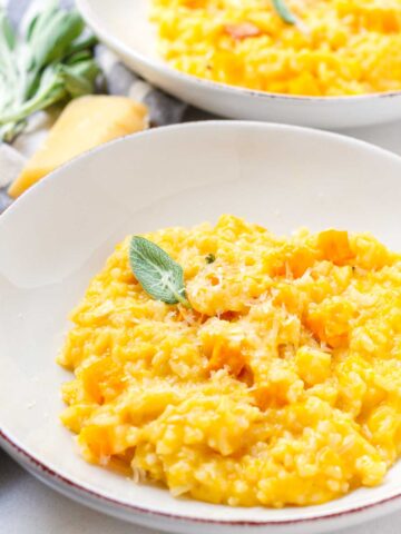 garnished butternut squash risotto served on shallow bowls