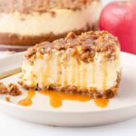 a slice of cheesecake with apple topping and caramel