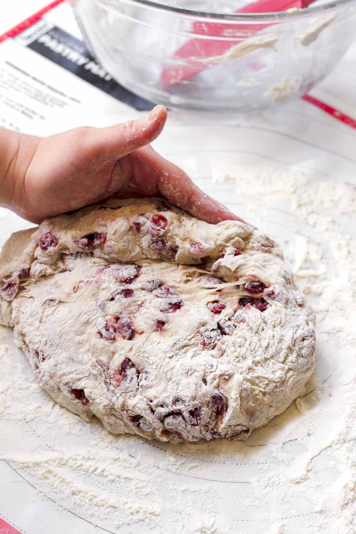 pulling side of the dough into center with hands