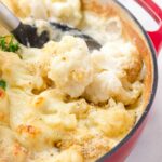 scooping out a floret of cheesy baked cauliflower gratin
