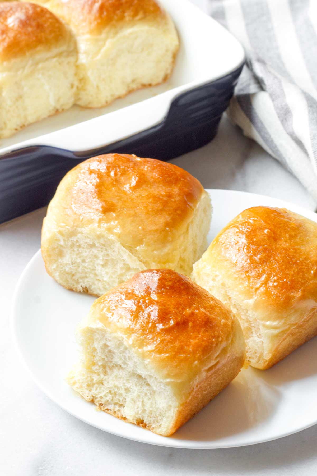 three individual dinner rolls on a plate