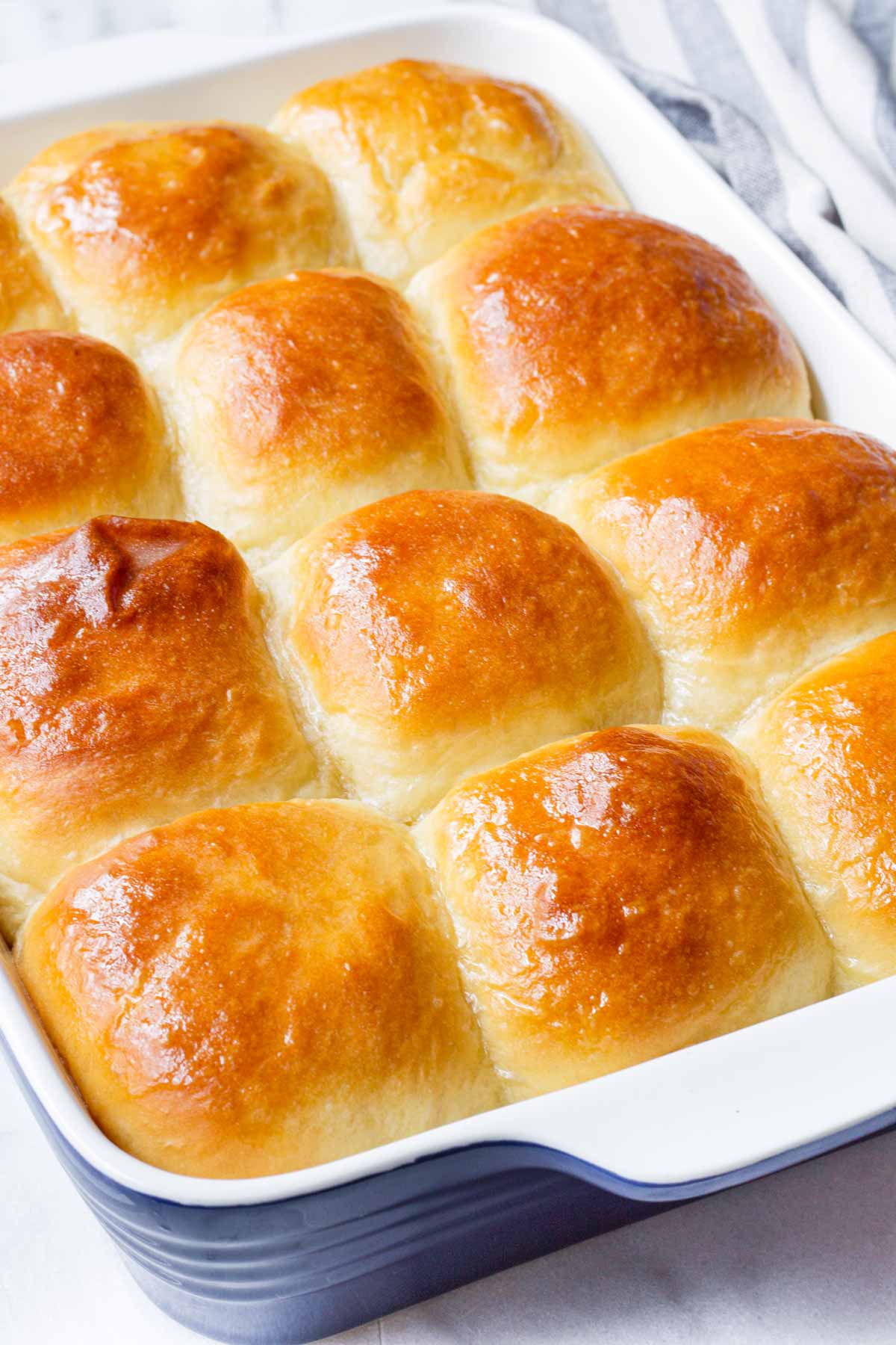 a whole baking dish with tall soft butter rolls