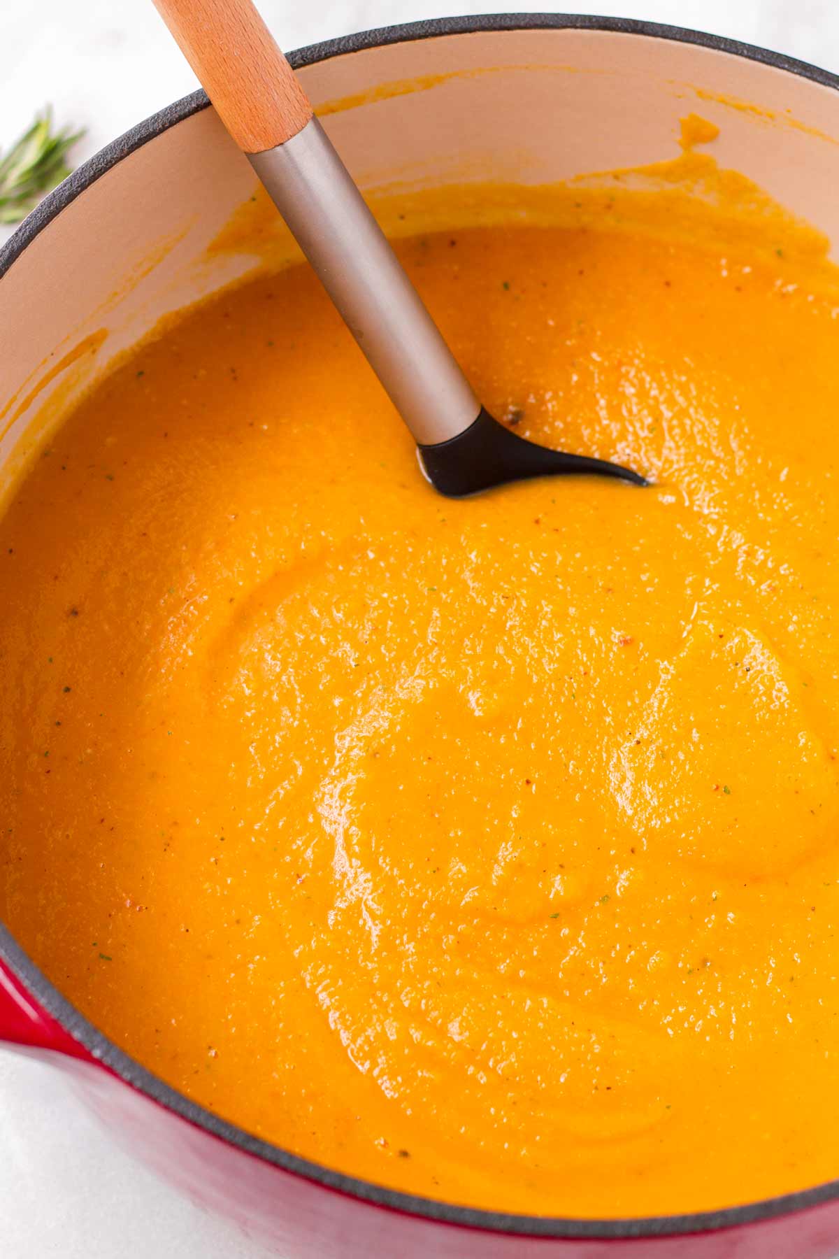 stirring a blended butternut squash soup in dutch oven