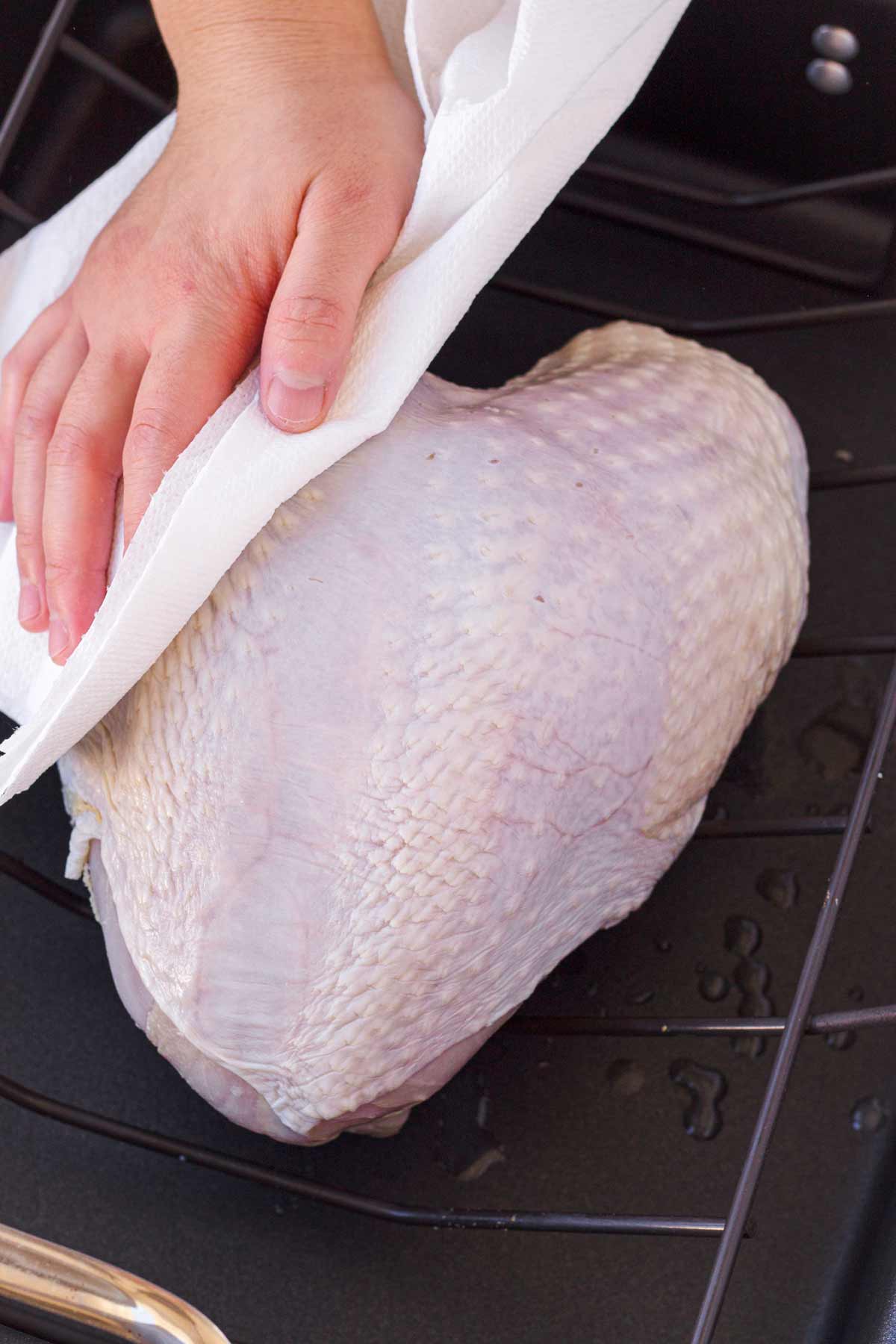patting dry a brined turkey breast with paper towel