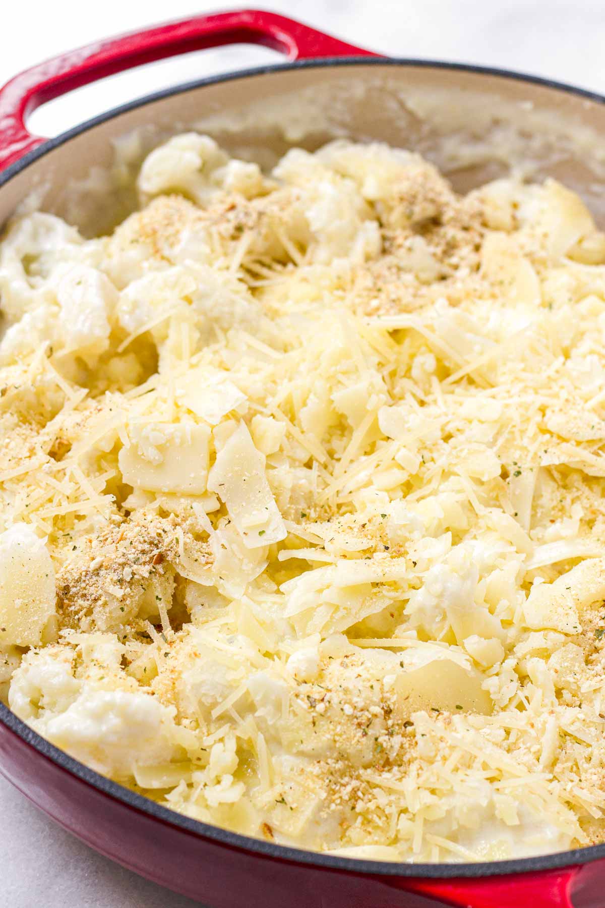 cauliflower mixed with cheese sauce and topped with cheese before baking