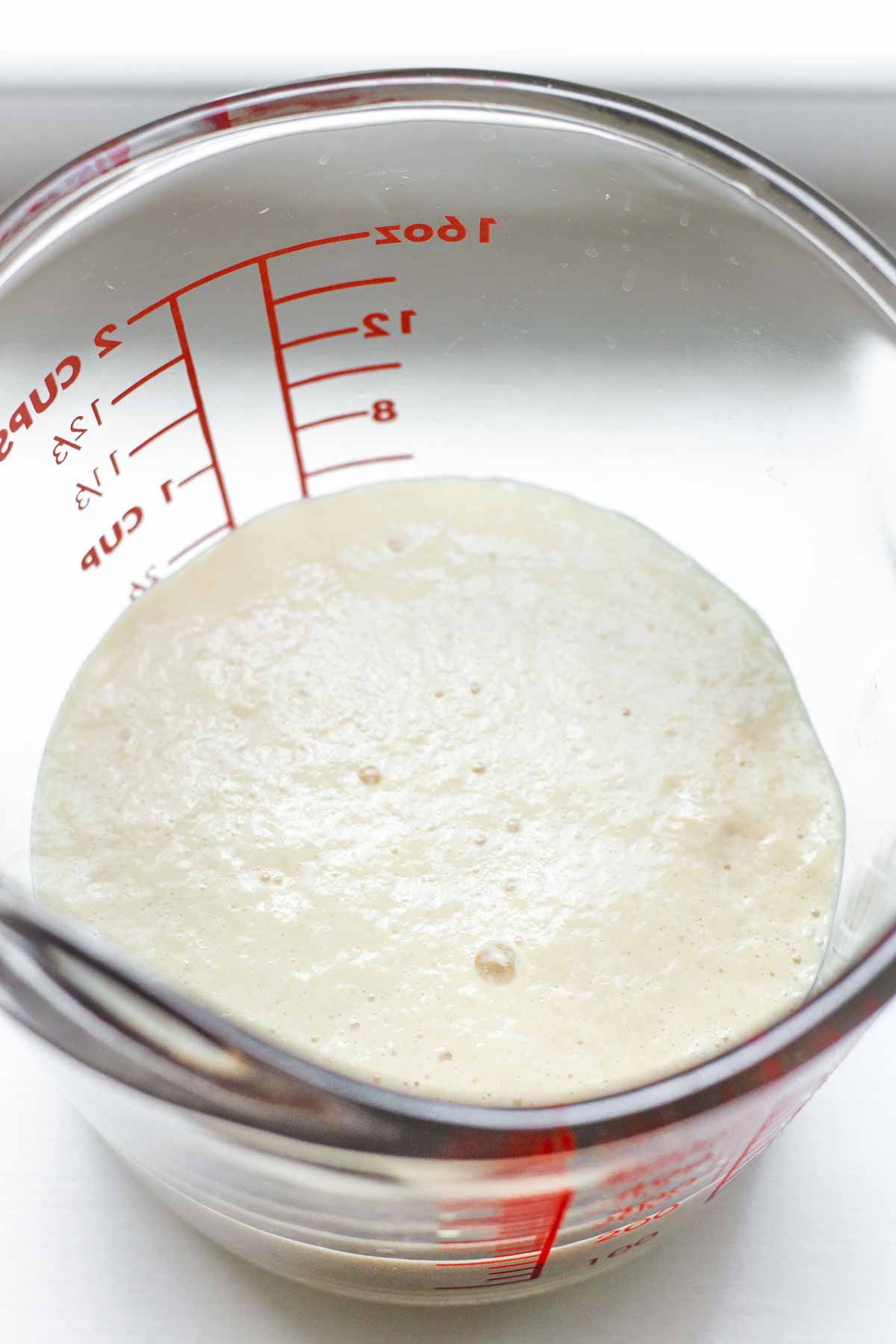 yeast foamed up in a glass measuring cup