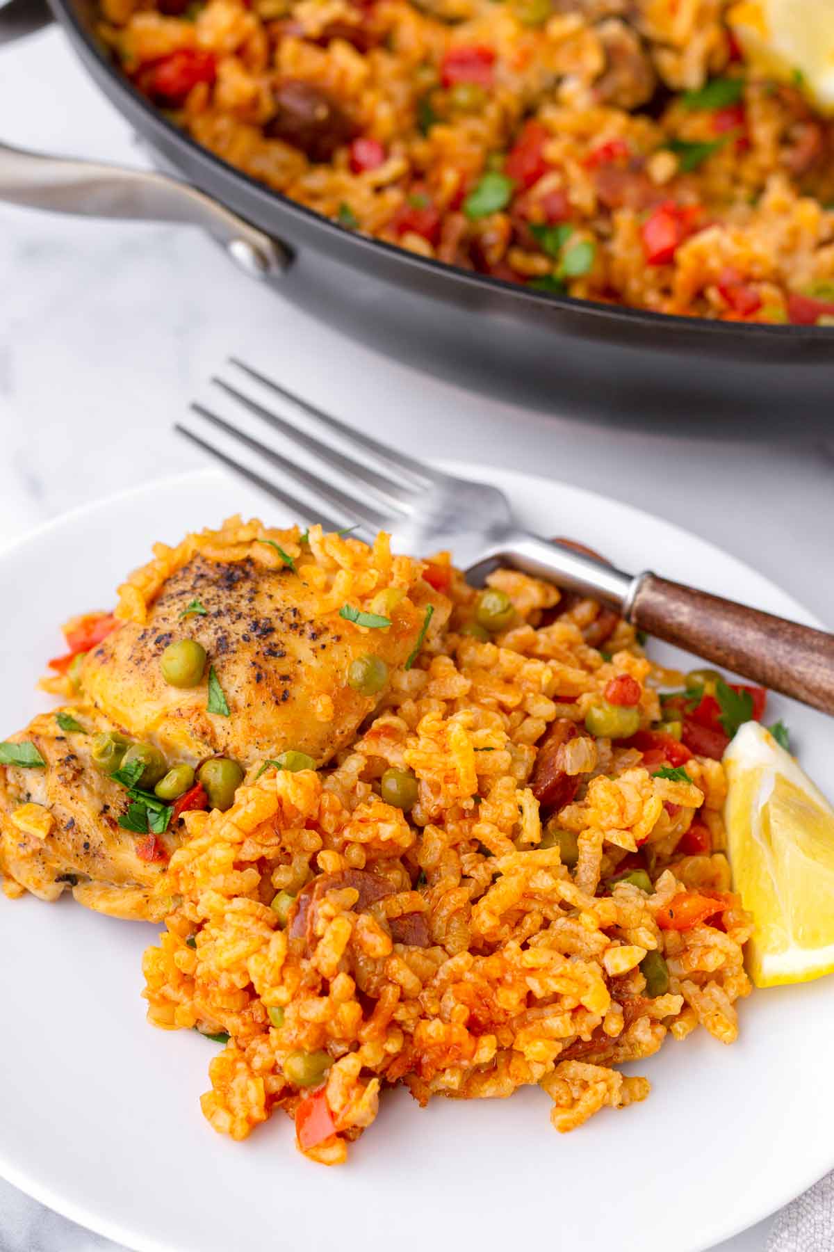 a serving of chicken chorizo paella on plate with a fork