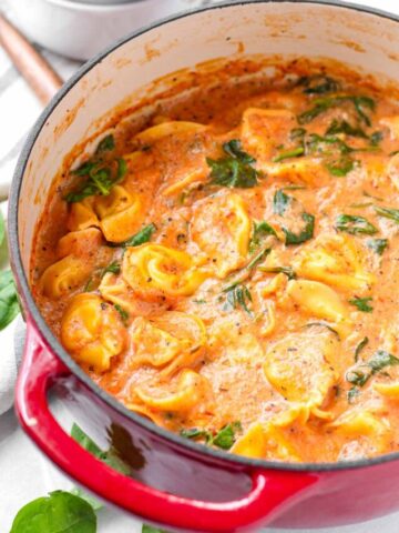 tomato tortellini soup with spinach in a dutch oven