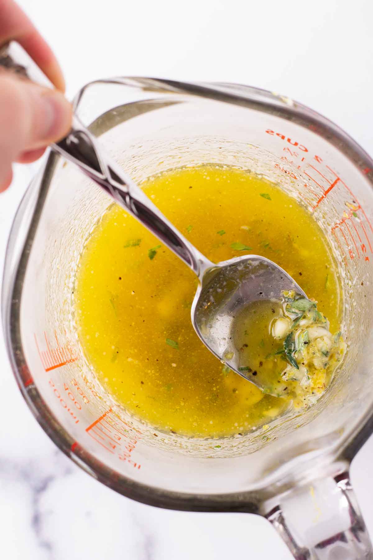 making the lemon garlic herbed butter in a measuring cup