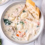 a bowl of chicken gnocchi soup with bread