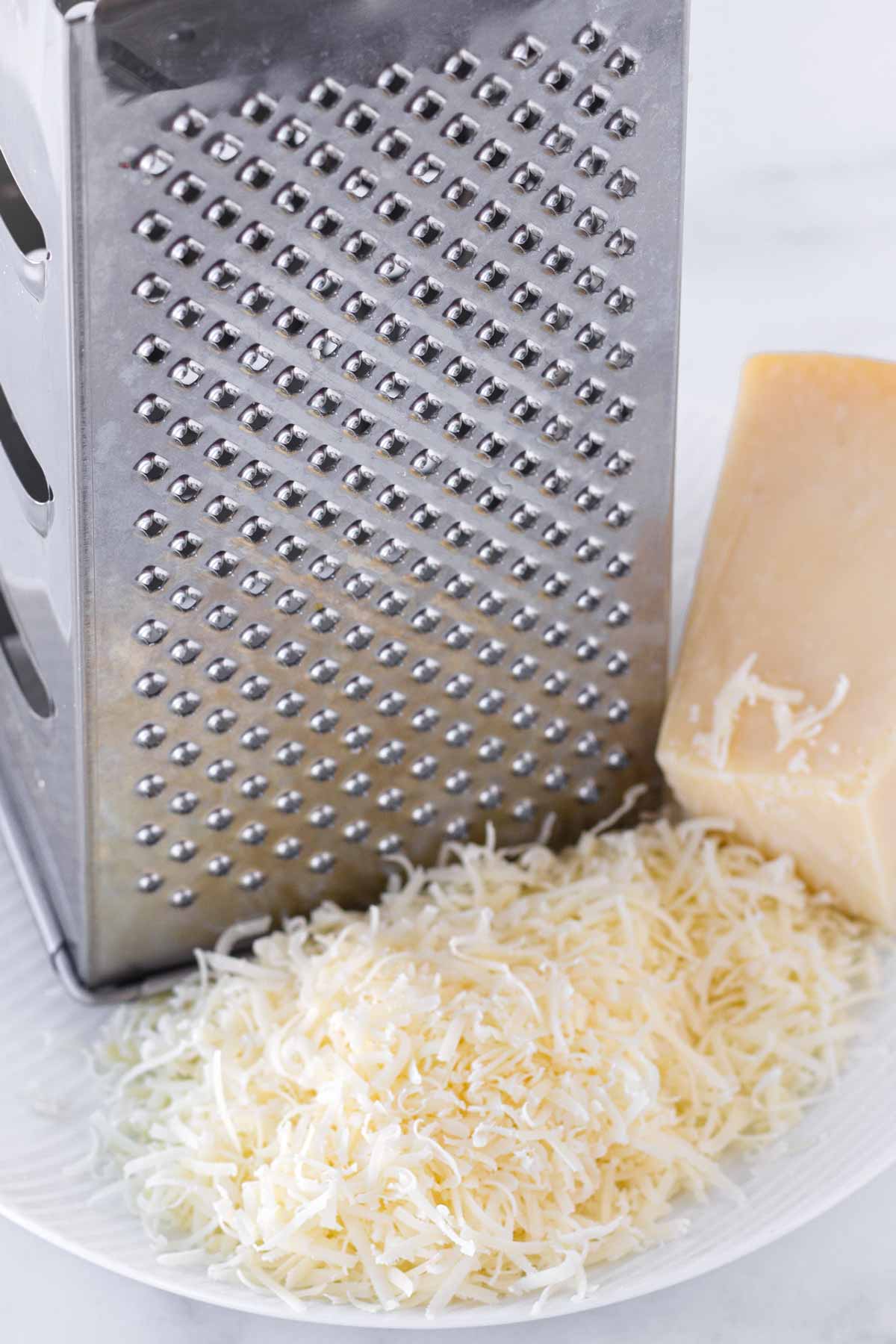 grated parmesan cheese next to a box grater