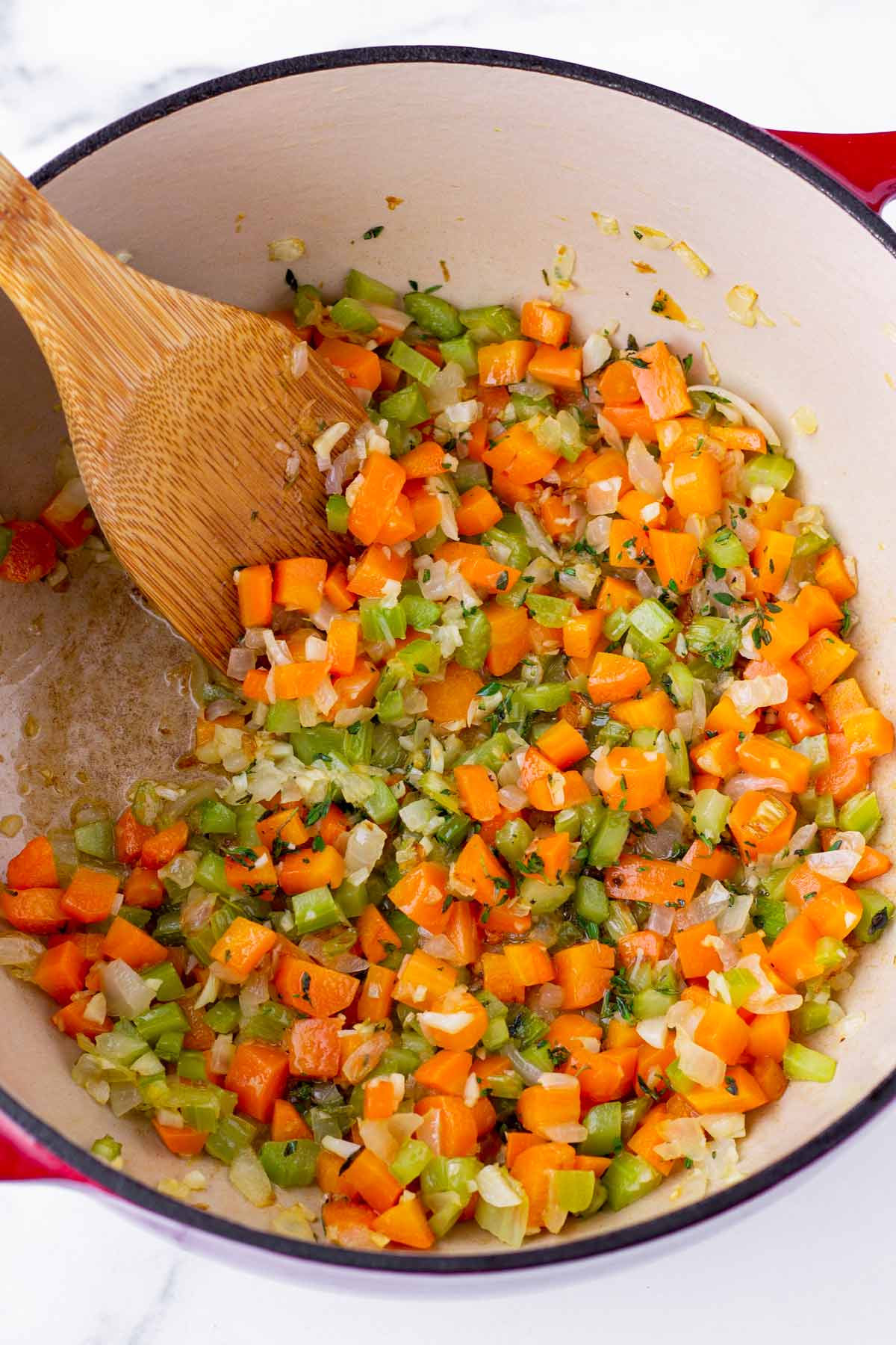 sauteeing carrots, celery, and onions in a pot