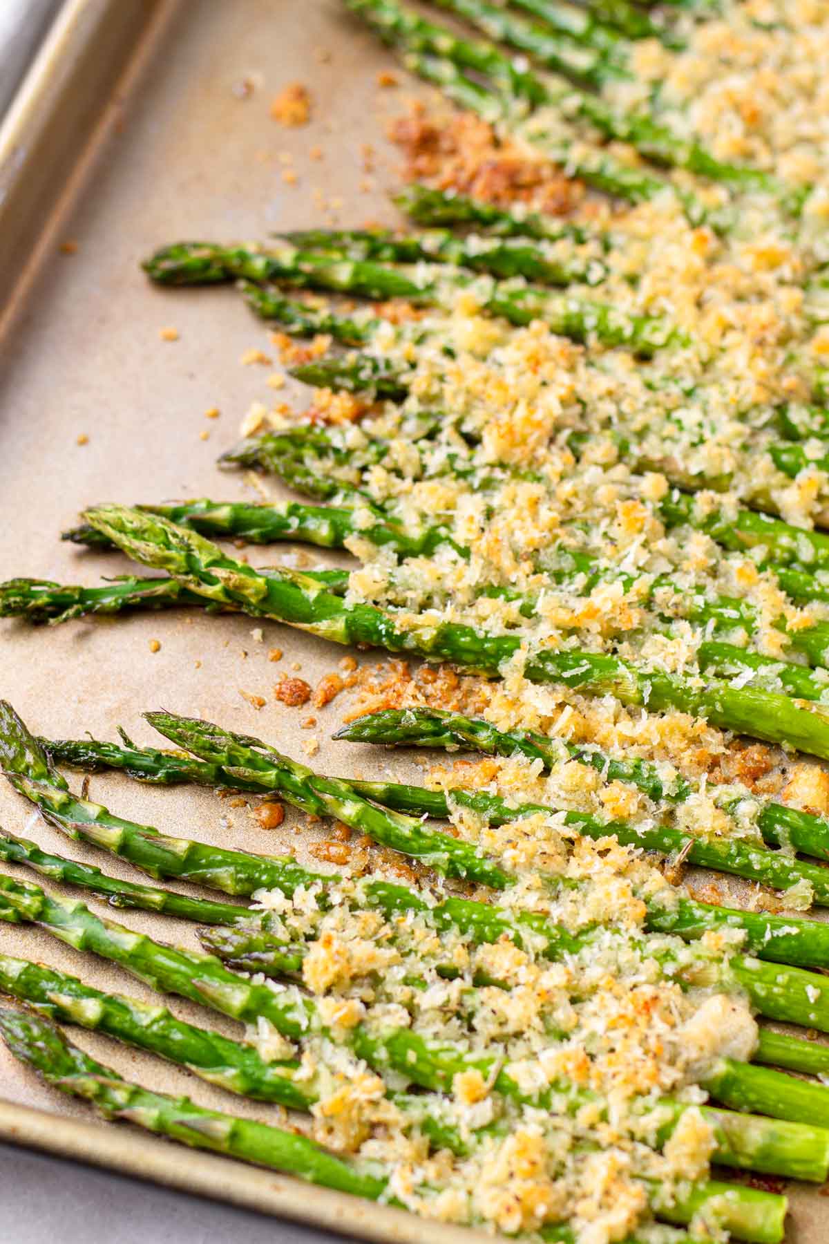 baked bright green asparagus with parmesan topping on sheet pan