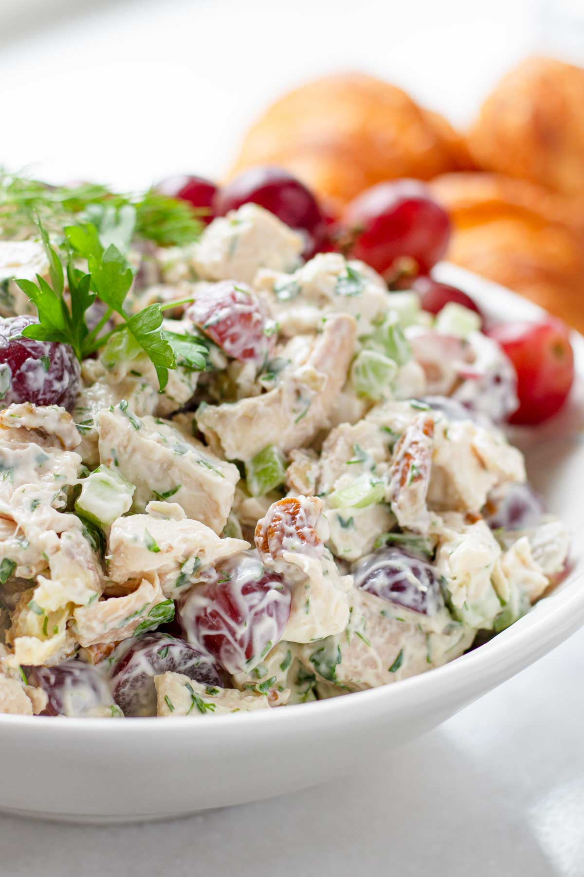 side view of a bowl of fresh chicken salad with grapes