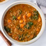 a bowl of lentil kale soup with carrots