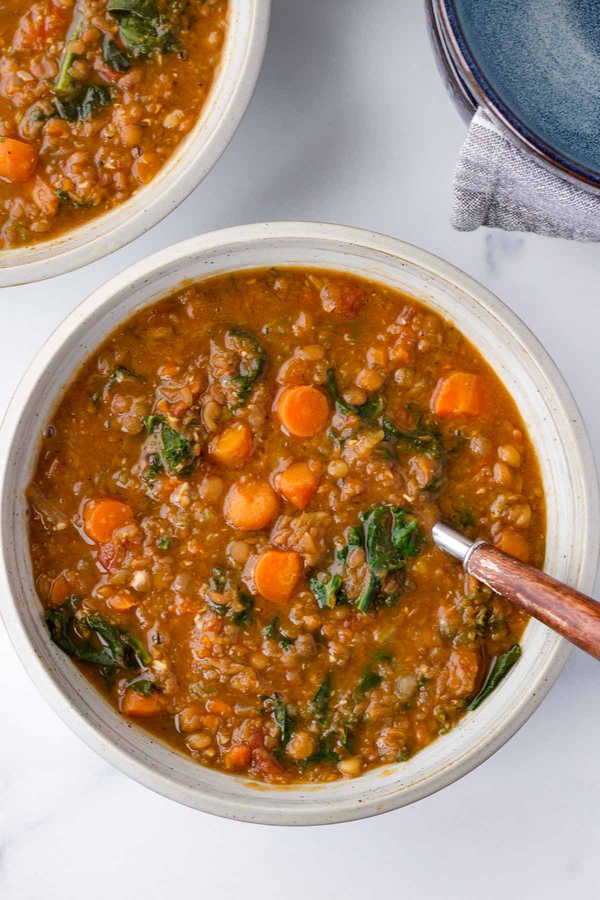 a bowl of lentil kale soup with carrots