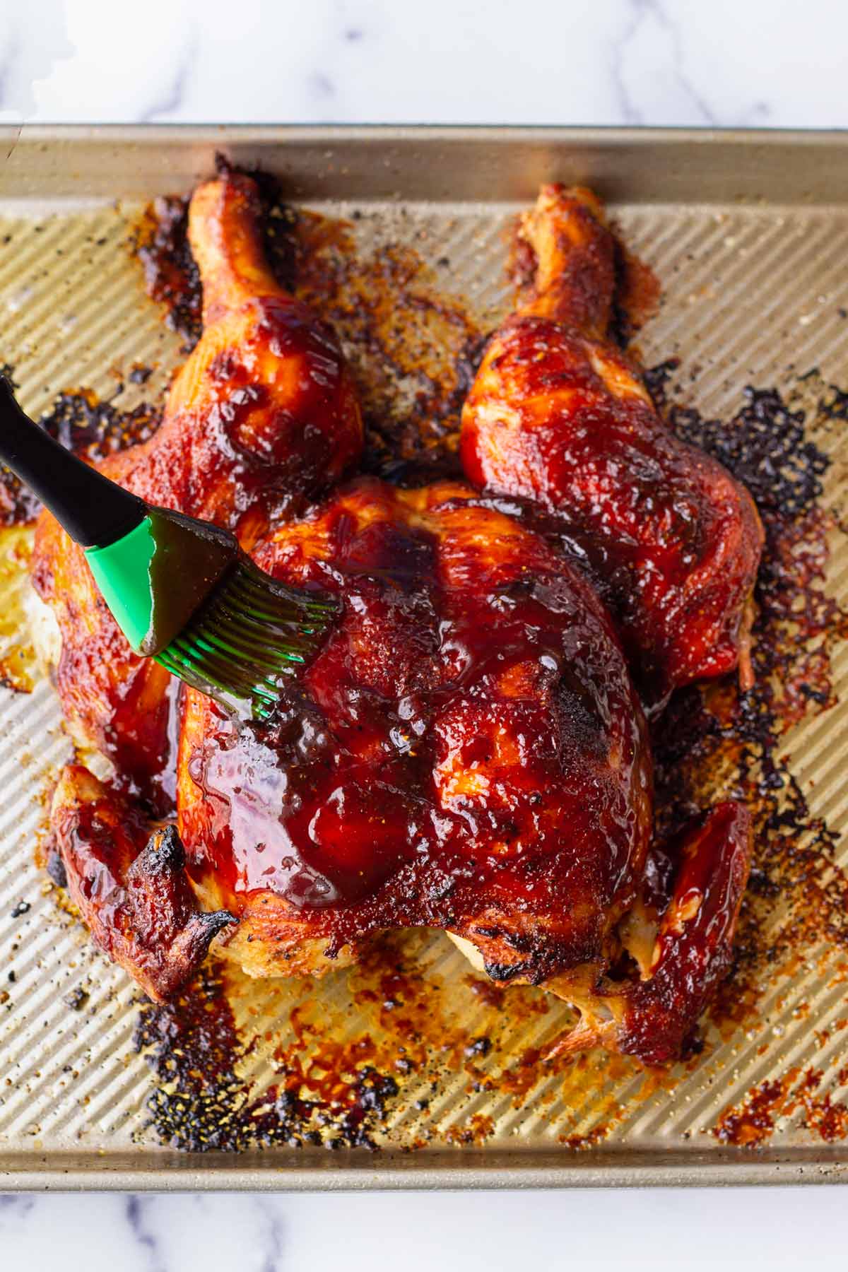 brushing whole chicken with bbq sauce