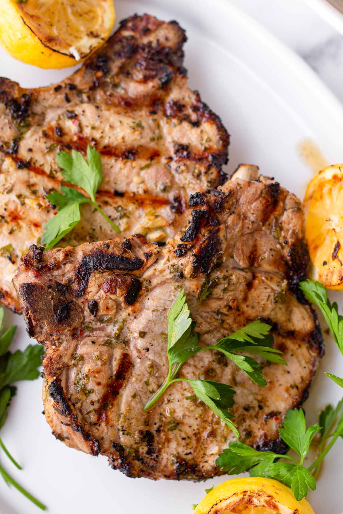 two grilled pork chops with garnish